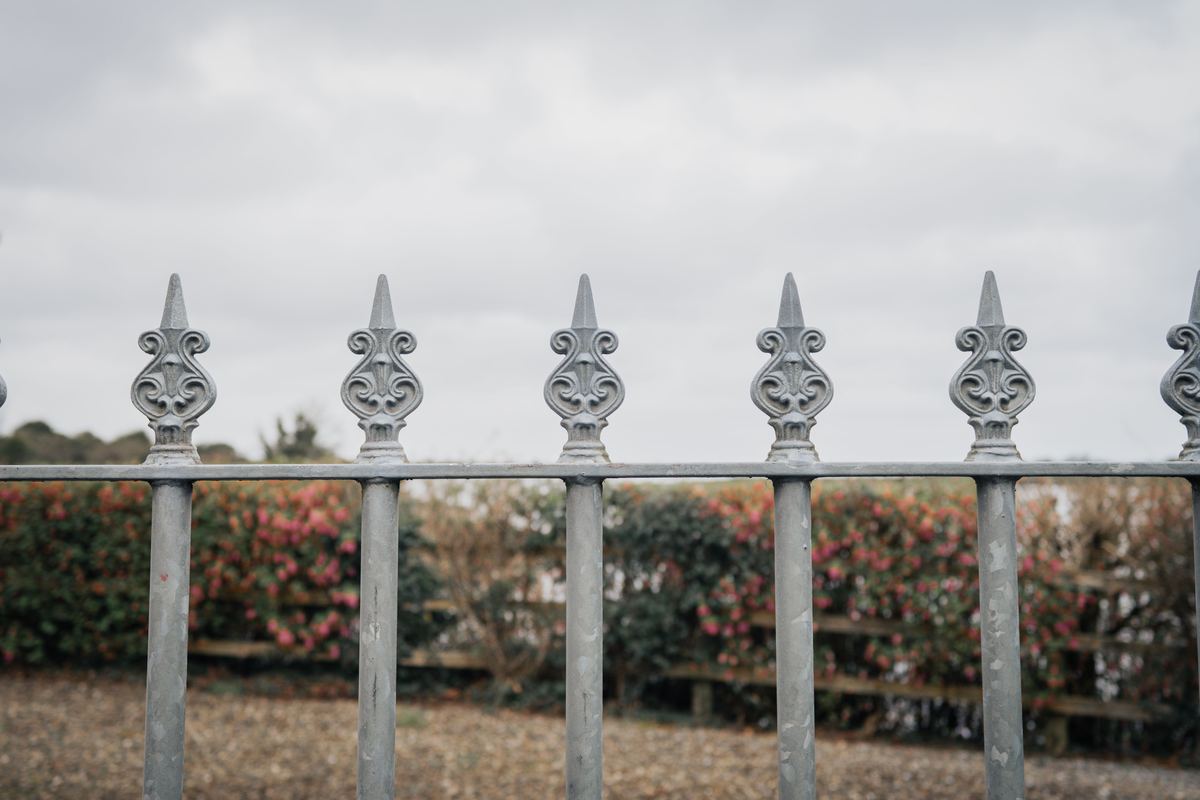 An ornate iron fence in a garden