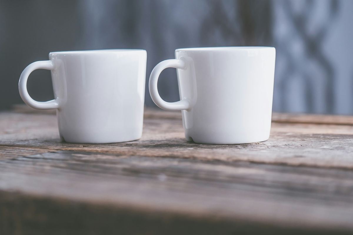 Two white teacups side by side on a table