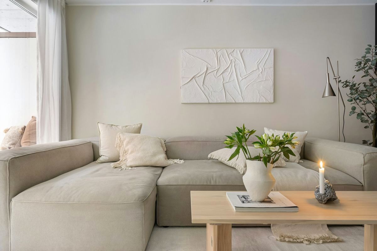 A quiet sitting room with a sofa, a low table and a large window