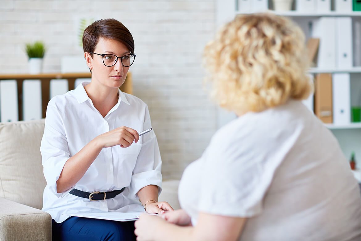 Two people sitting together in conversation in a bright, calm room