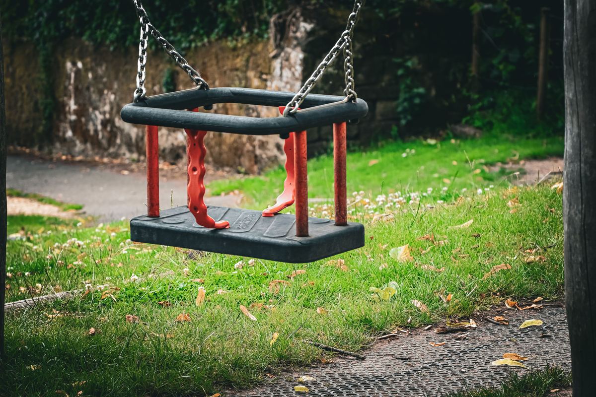 A single empty swing in a park