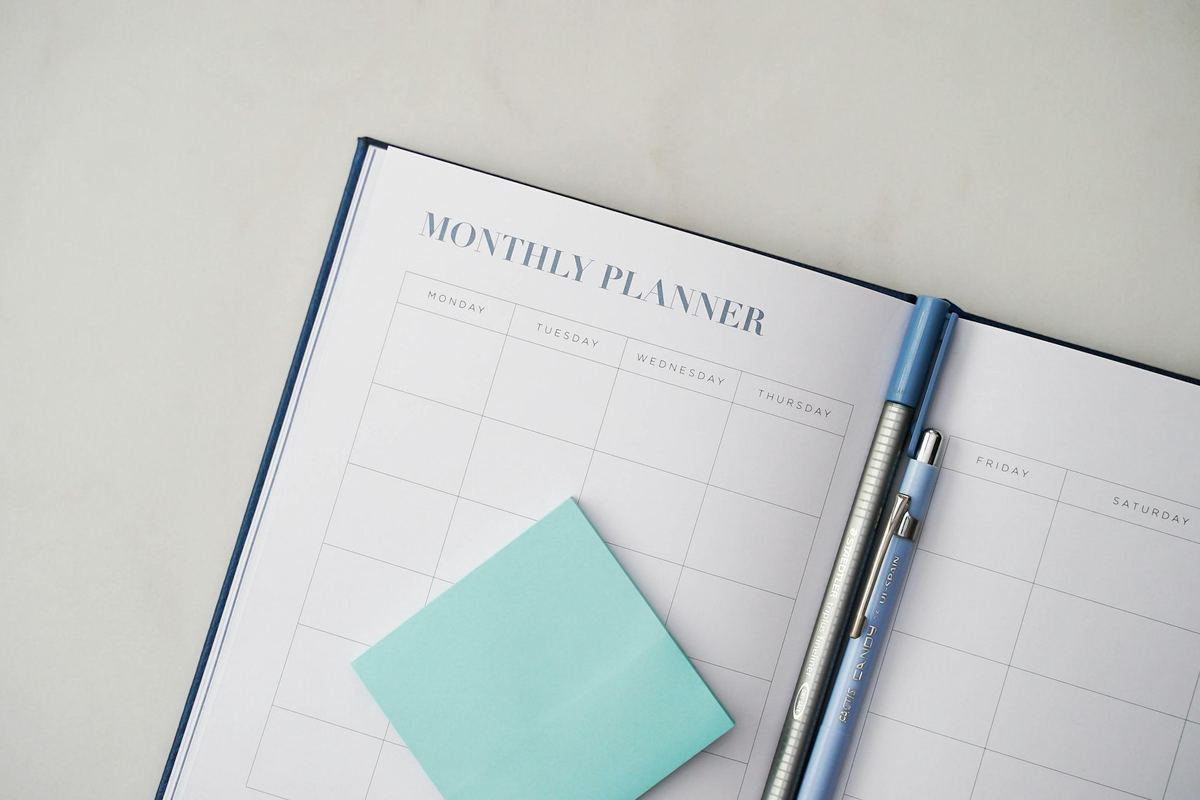 An open planner with a pen resting on it