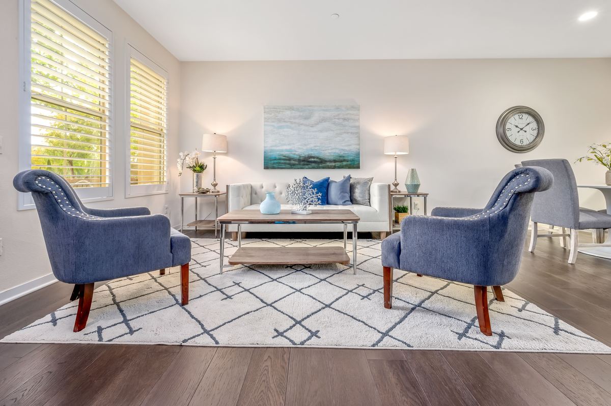 A bright living room with two armchairs and a sofa