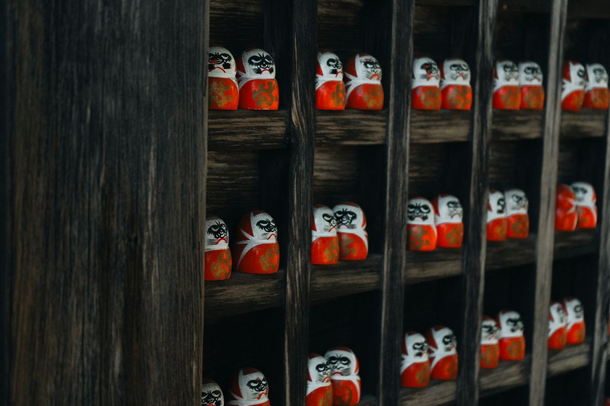 Rows of small wooden dolls on wooden shelves