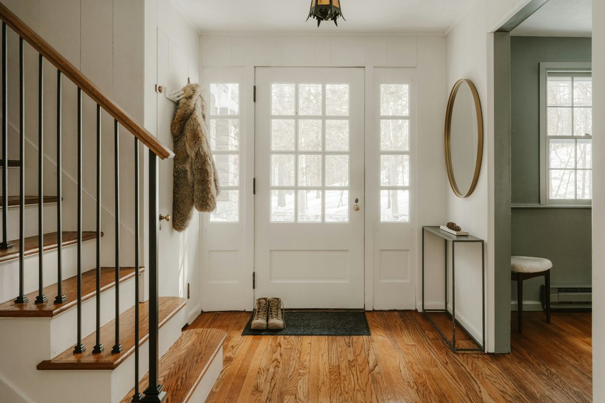 A home entryway with wooden stairs and a glass door