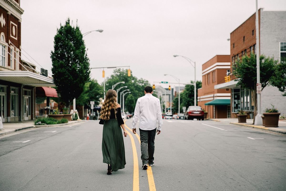 Two people walking together along a quiet street