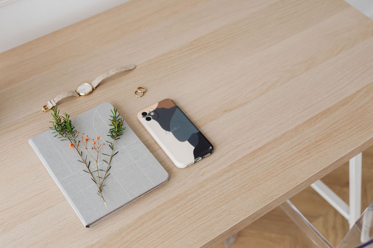 A phone and notebook on a minimalist desk