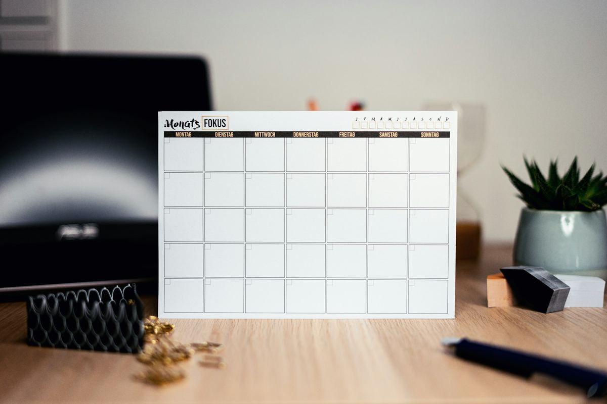 A blank monthly calendar standing on a desk