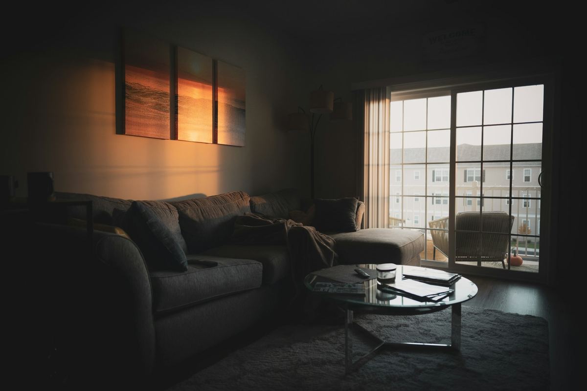 A sofa beside a window in low evening light