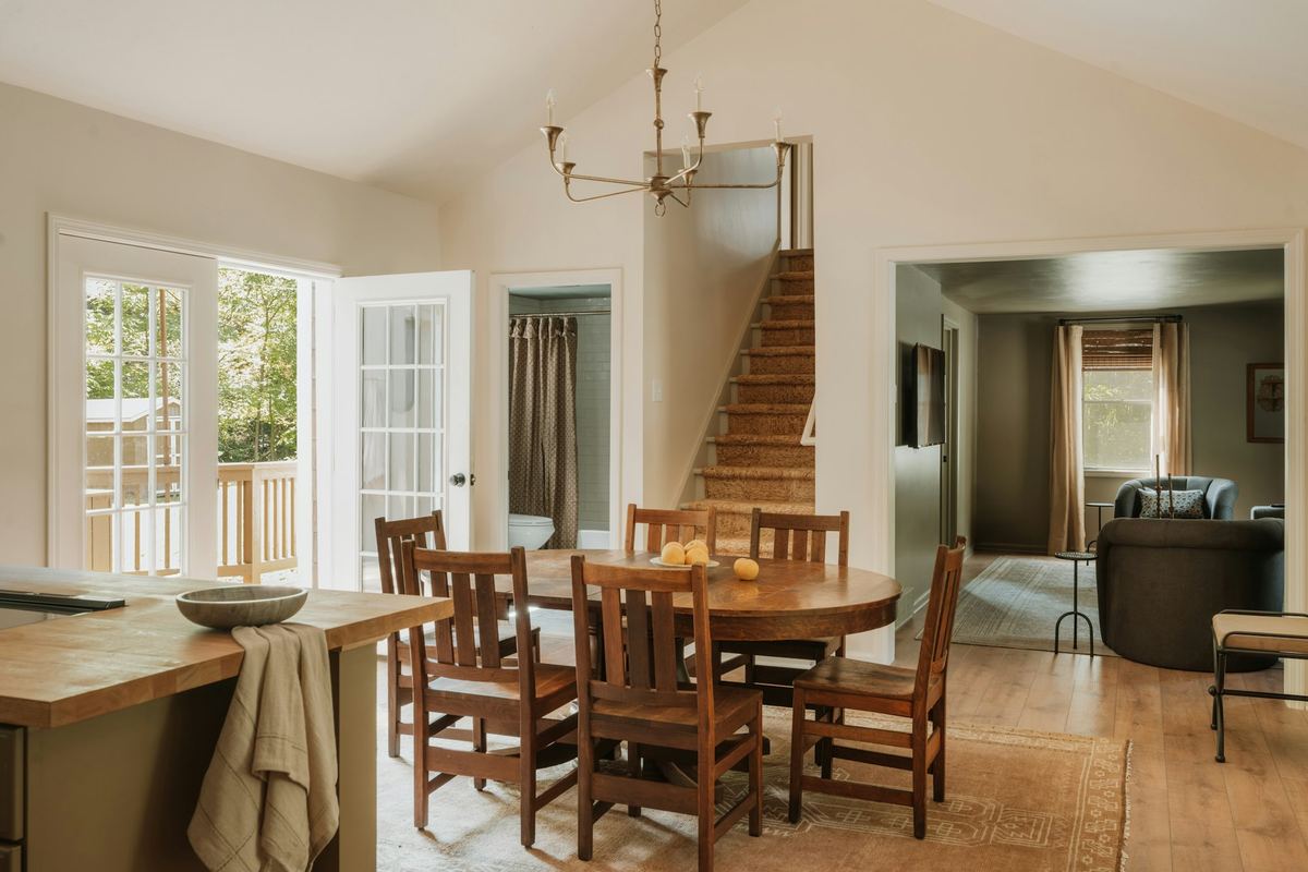 A dining area with a wooden table and stairs beyond