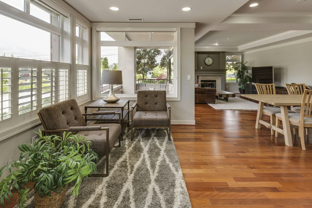A bright open-plan living room with seating and a dining area