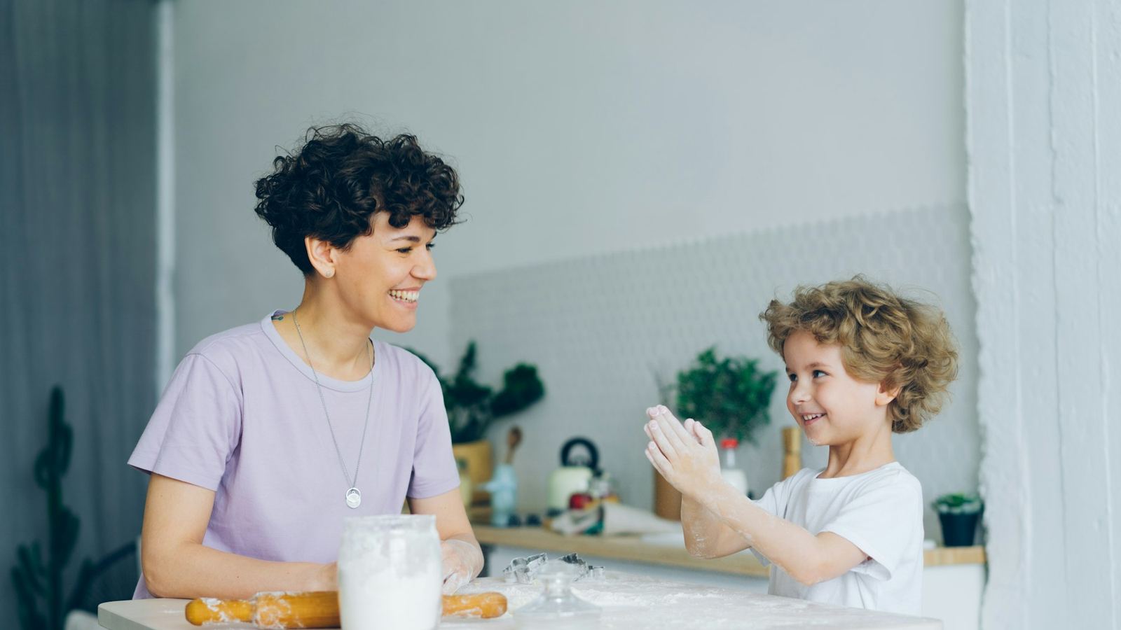 A parent and child talking together at a kitchen table