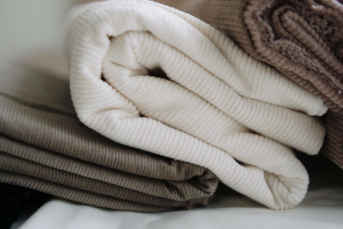A stack of folded blankets in neutral tones