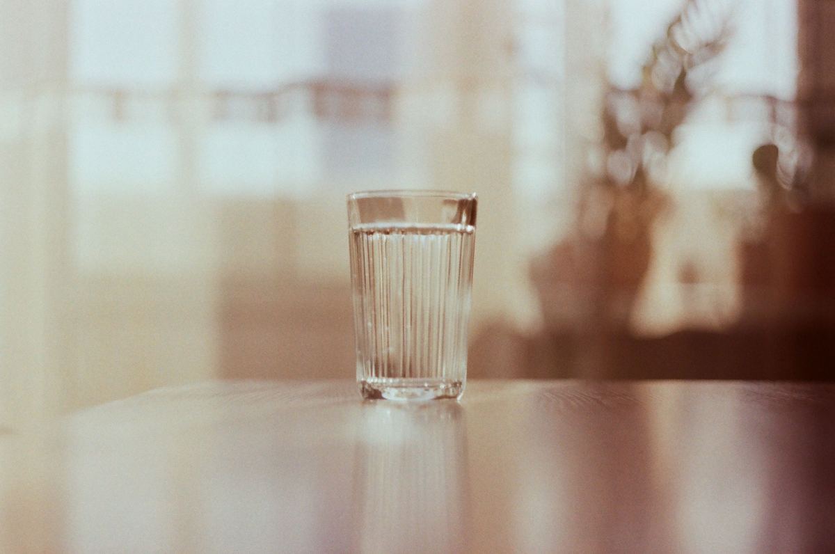 A glass of water on a table in warm light