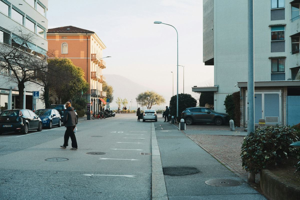A person crossing a street lined with buildings