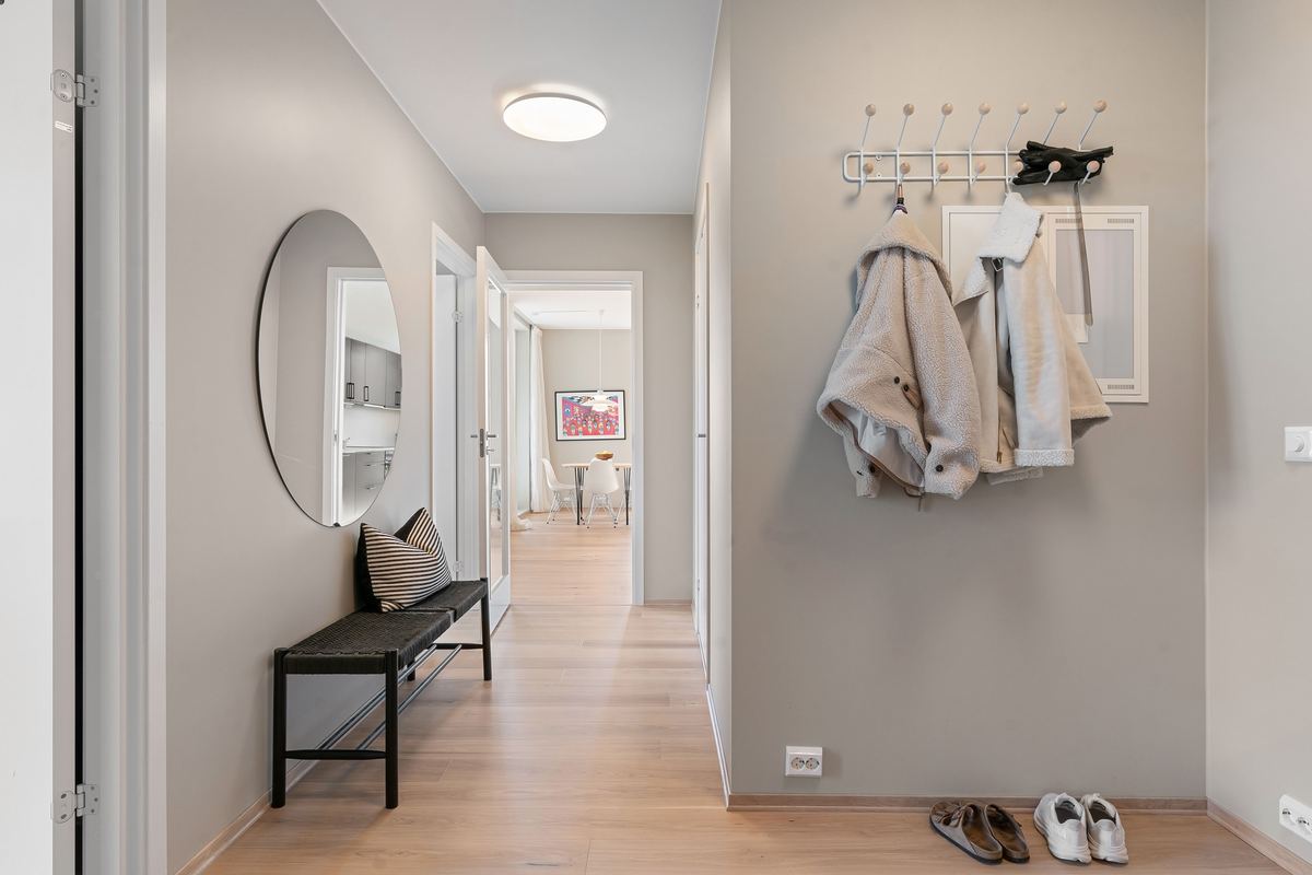 A hallway with coats and shoes by the door