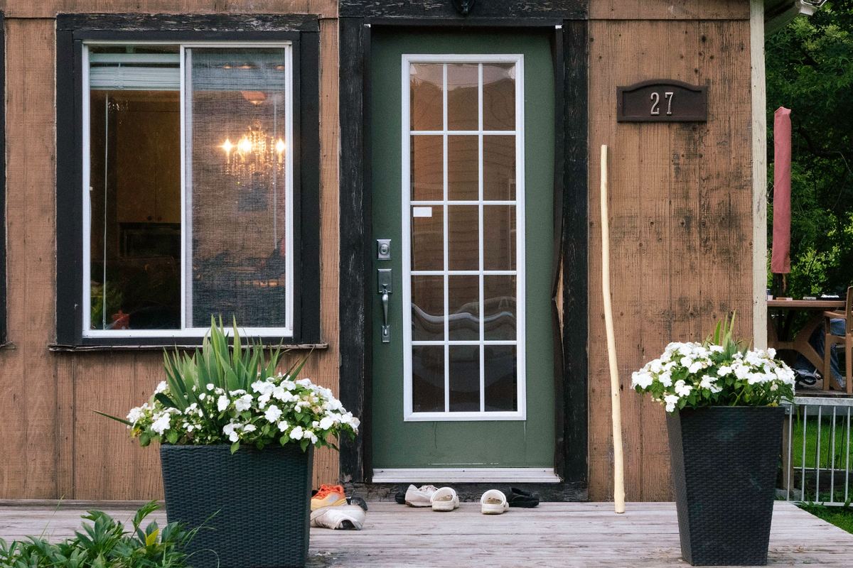 A house entrance with potted plants beside the door