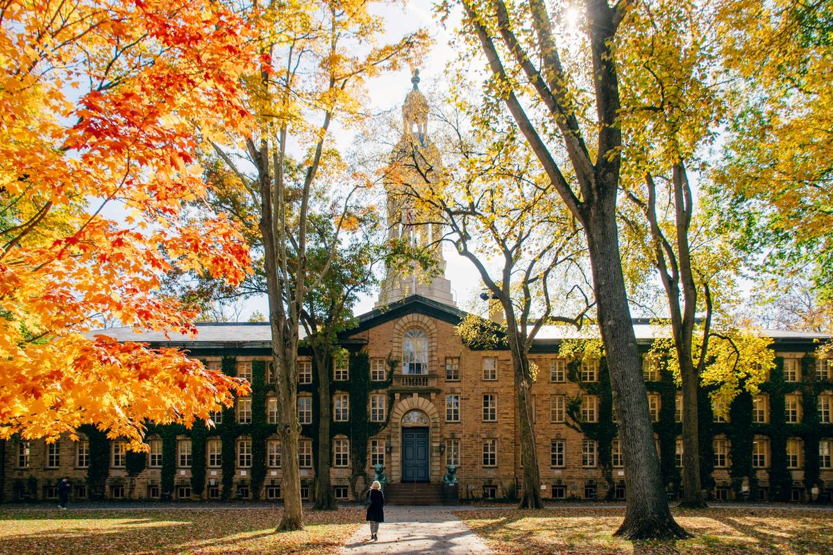 A person walking along a pathway in front of a university building