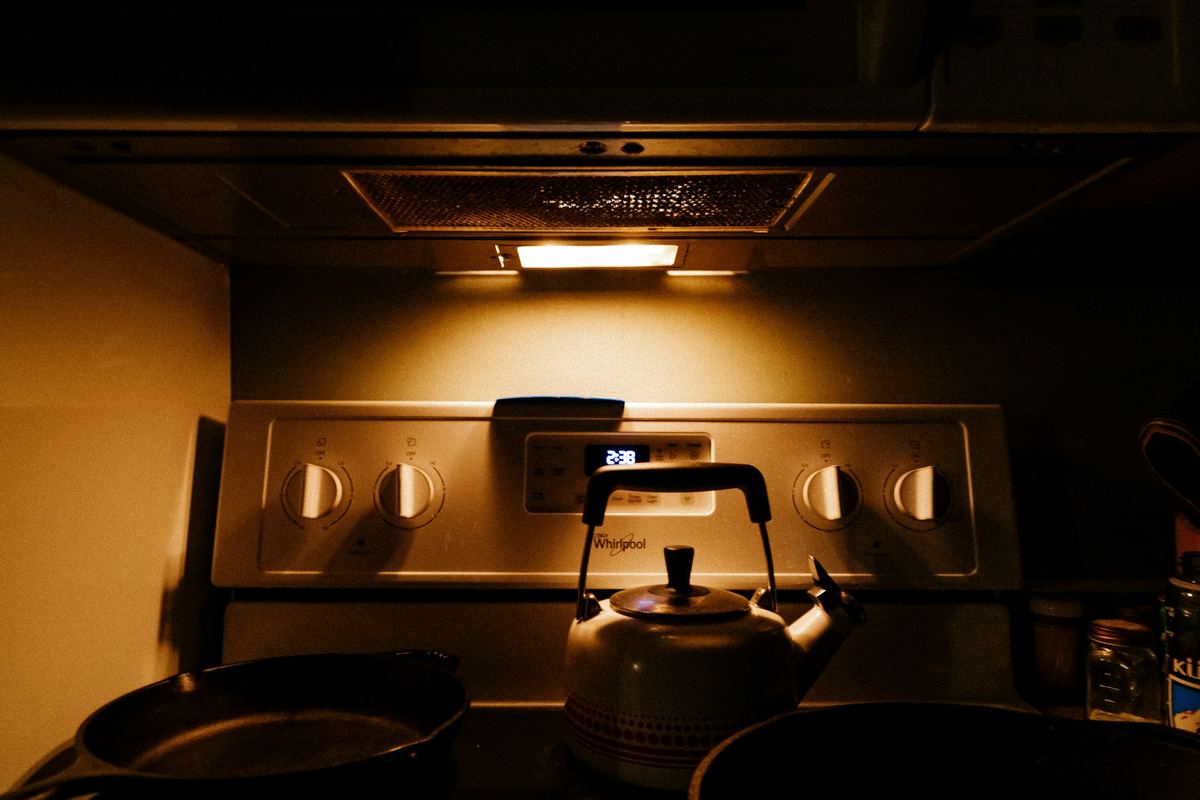 A kettle on a stove under warm light