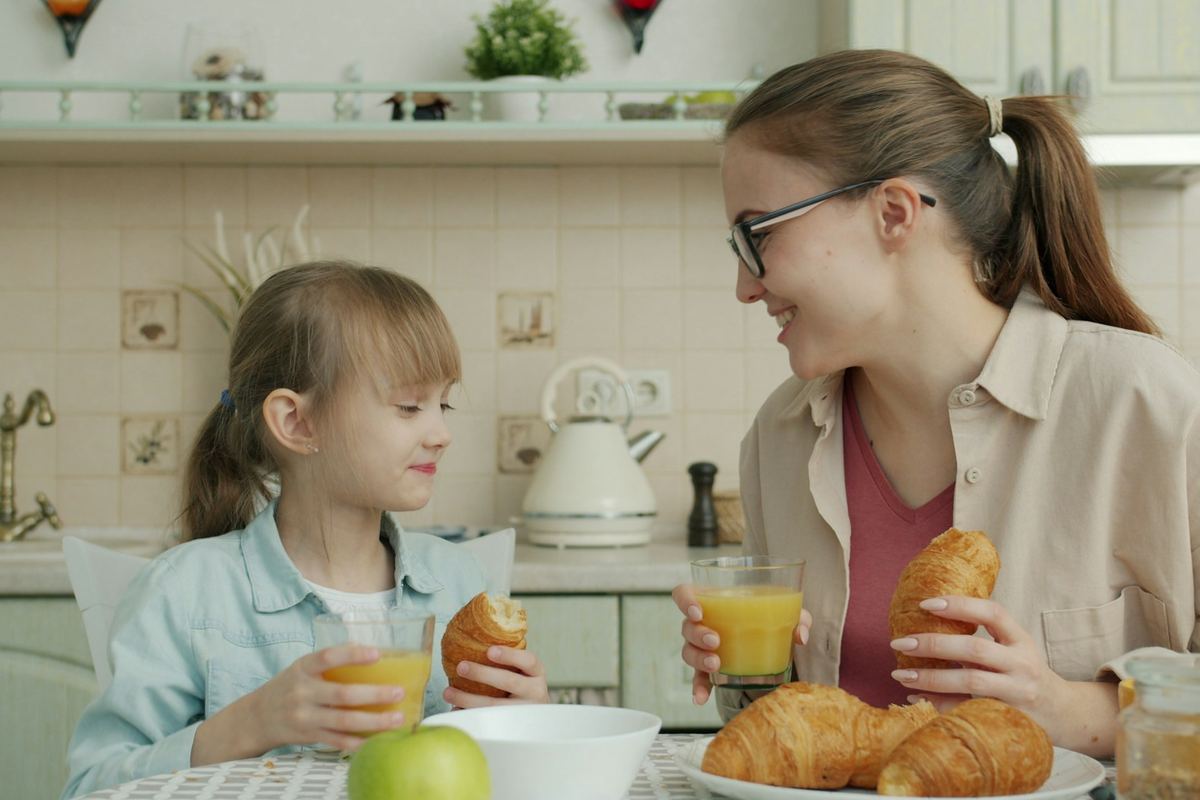 A parent and teenager talking together over breakfast