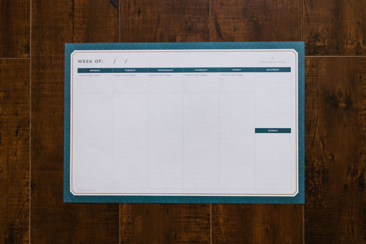 A blank weekly planner on a wooden surface