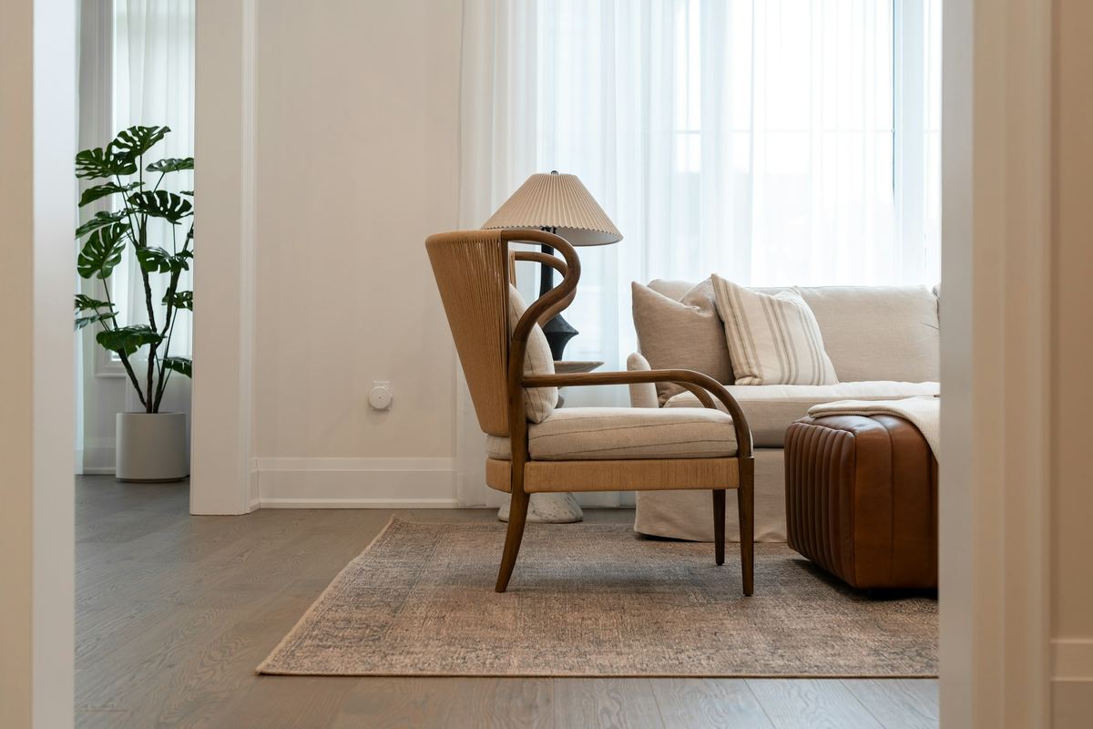 A living room with an armchair and sofa in soft daylight