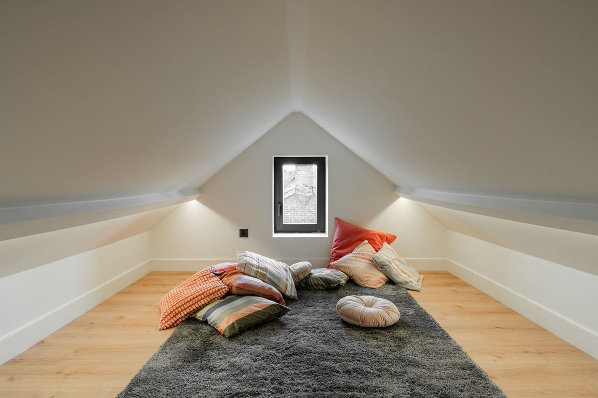 A quiet attic room with cushions on a rug