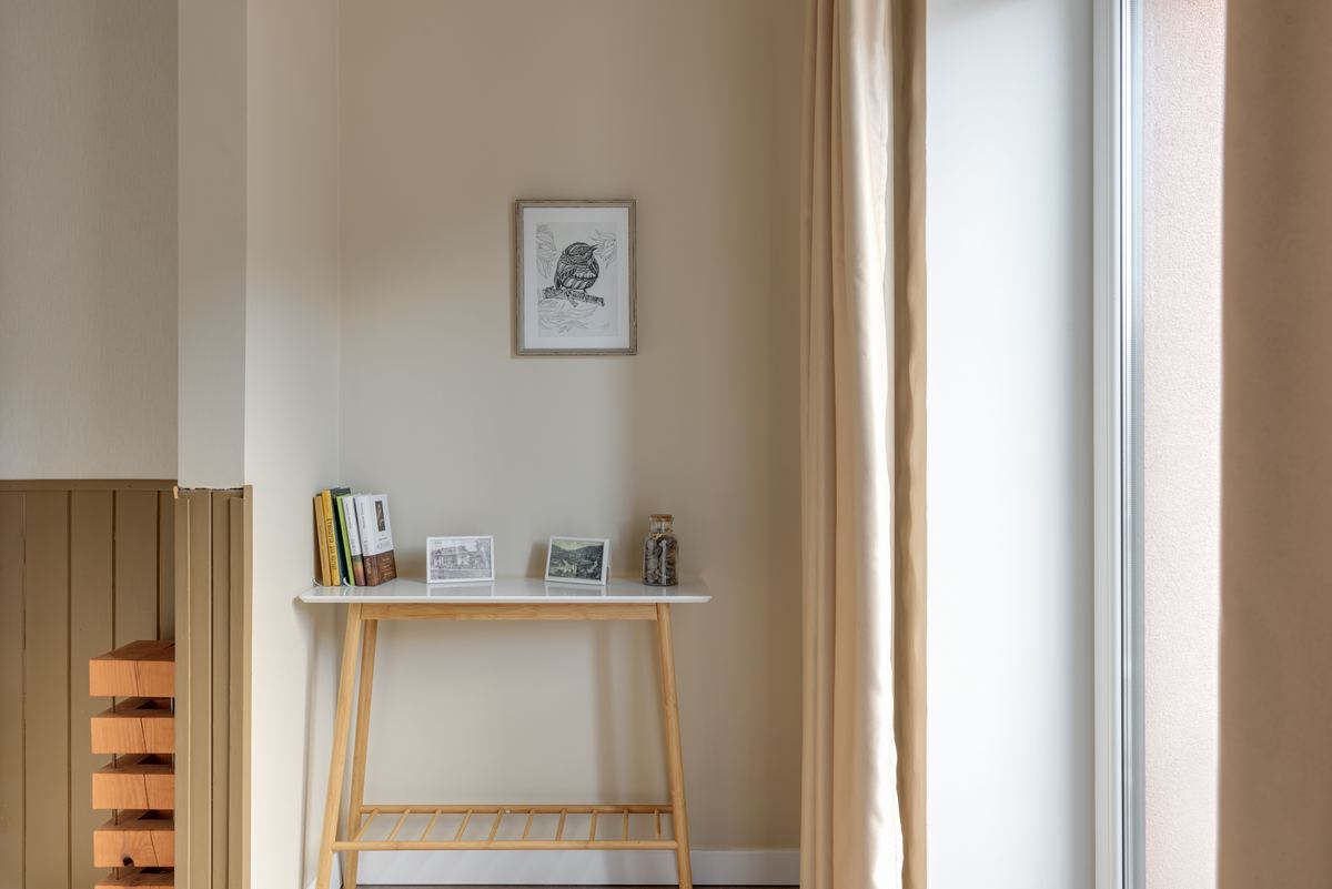 A quiet room with a wooden table and framed art