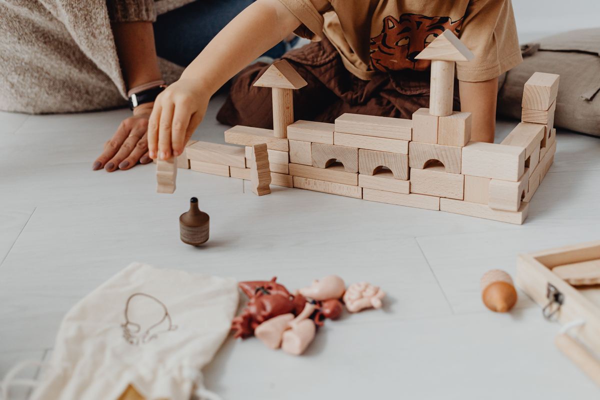 A child building calmly with wooden blocks