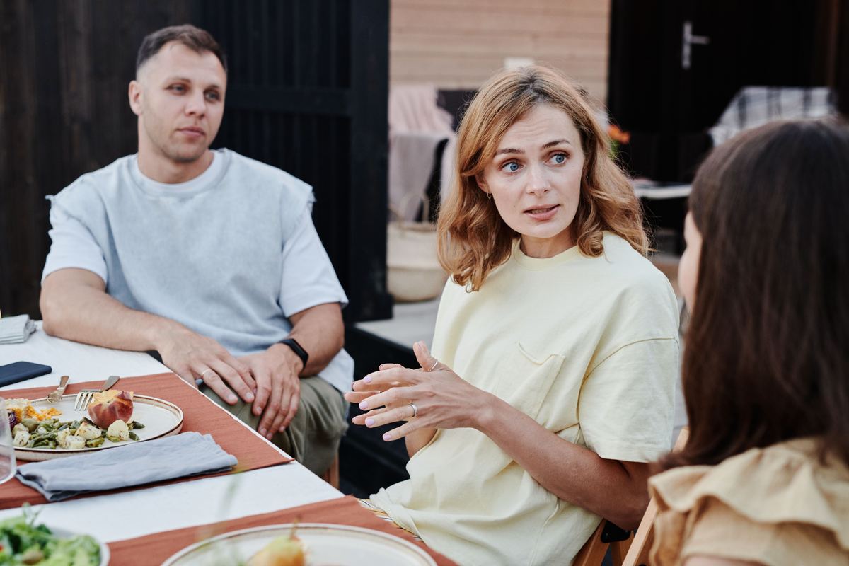 A group of adults sharing a relaxed meal outdoors