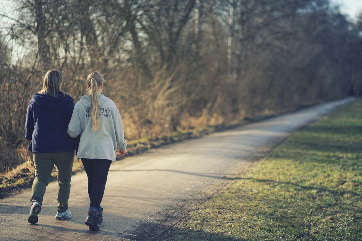Two people walking side by side along a path