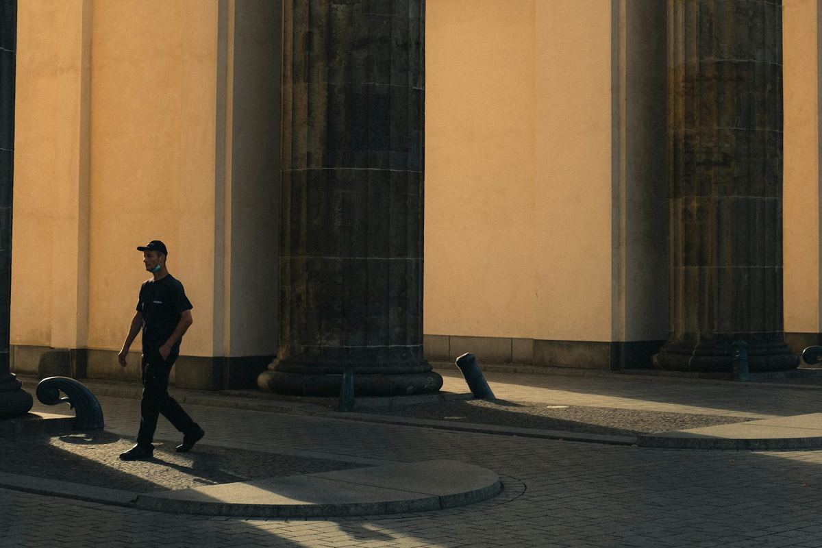 A person walking along a sunlit street
