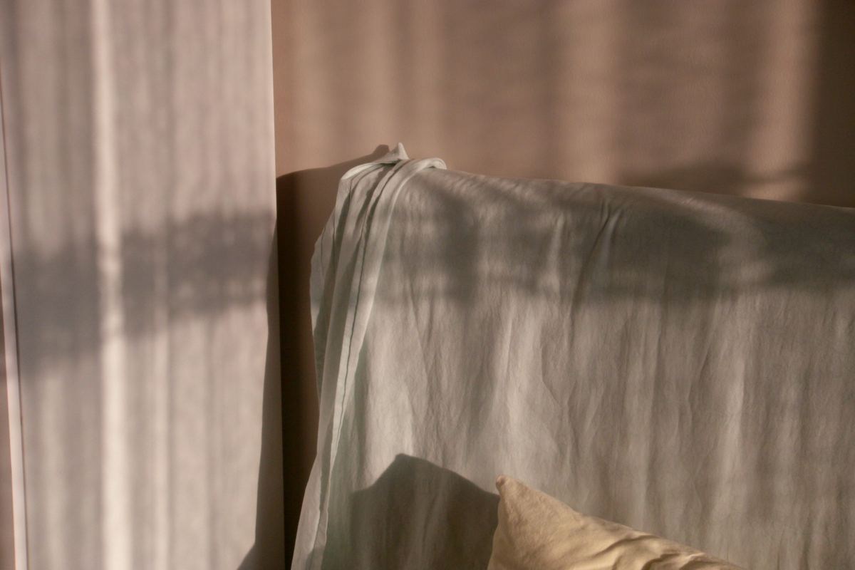 Sunlight casting shadows across a draped sofa