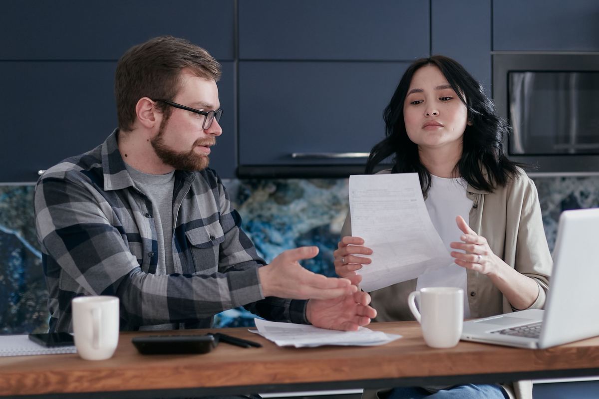 Two people discussing financial documents at home