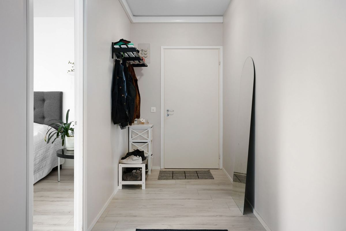 A hallway with coat hooks and an open doorway