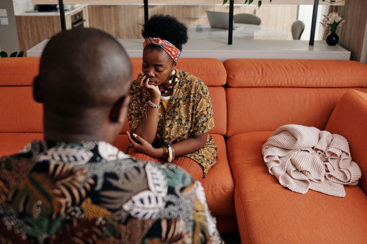 Two people sitting on a sofa in conversation
