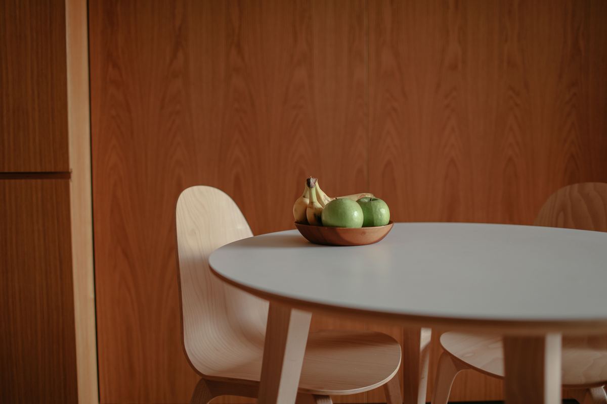 A bowl of apples and bananas on a wooden table