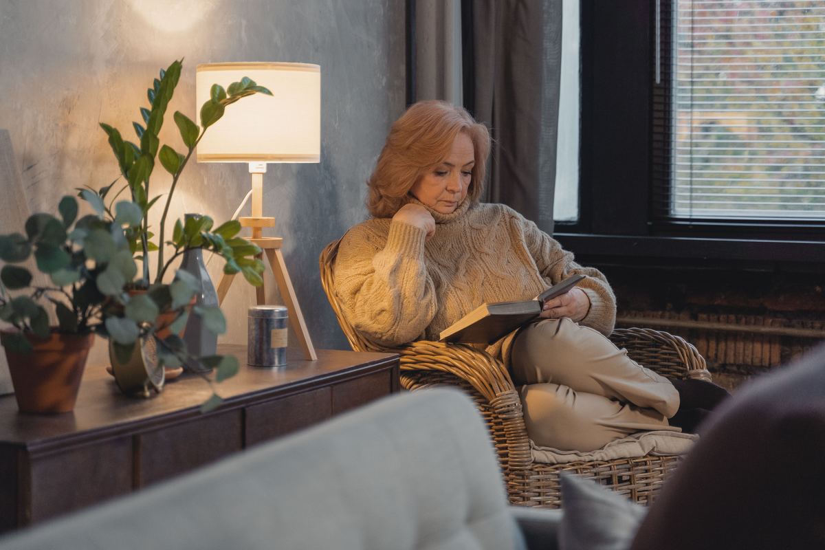 An older woman reading in a comfortable sitting room