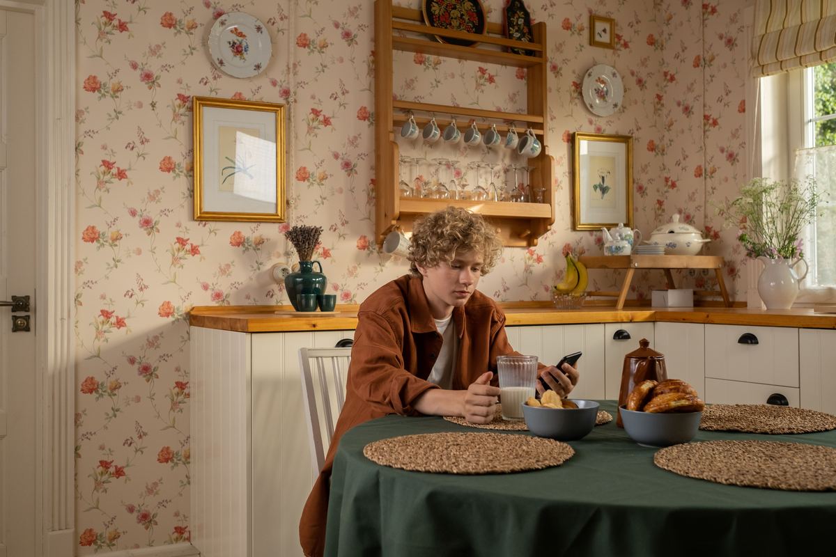 A young person eating breakfast at a kitchen table