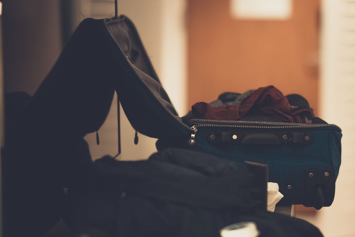 An open suitcase partly packed with clothes