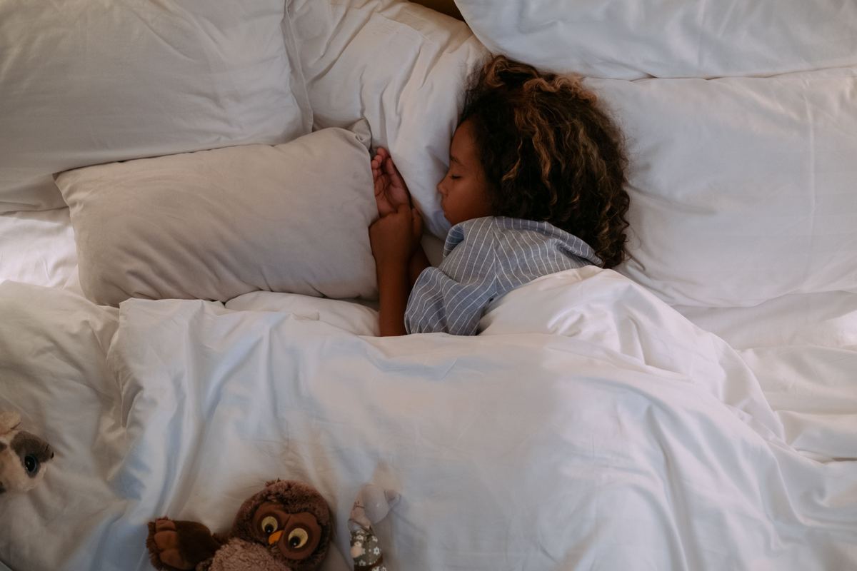 A child sleeping peacefully under soft bedding