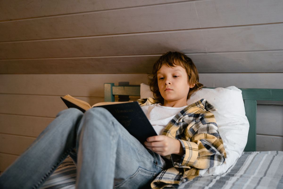 A child reading a book at home during the day