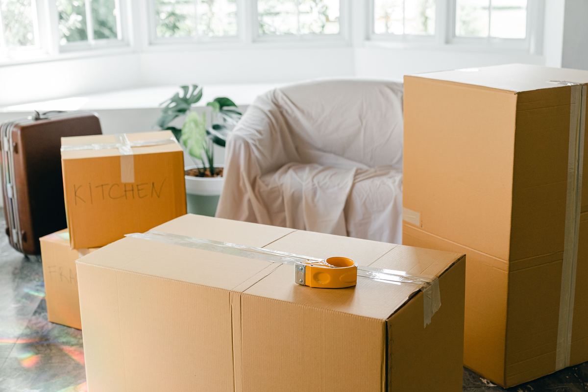 Cardboard boxes and a suitcase packed in a room