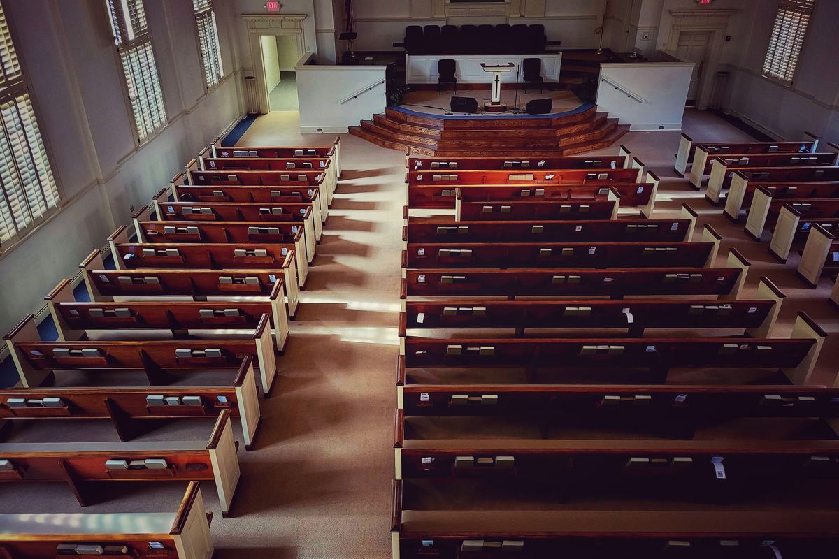 Empty wooden pews in a sunlit church interior