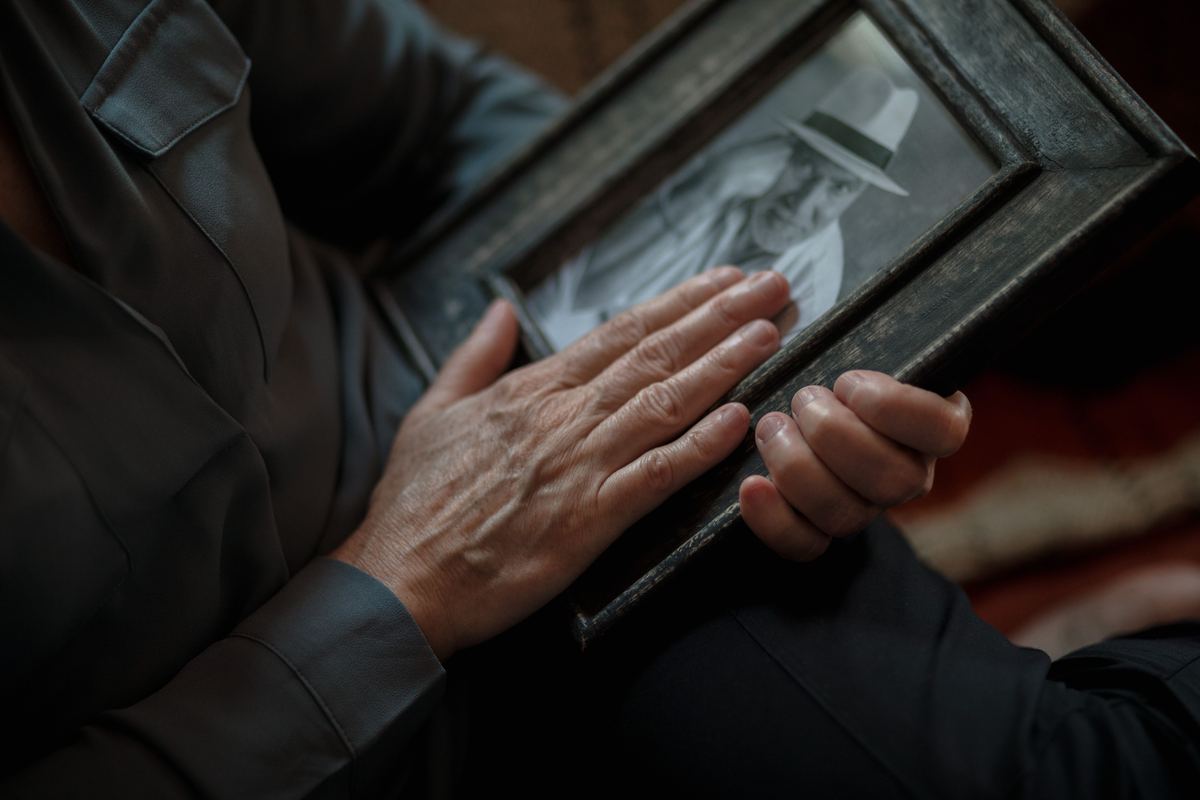 Hands holding an old framed photograph