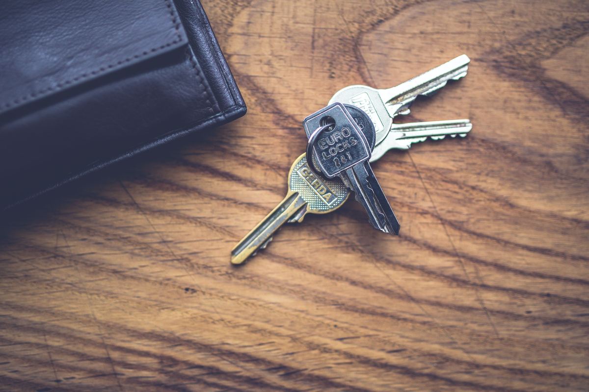 A wallet and a set of keys on a wooden table