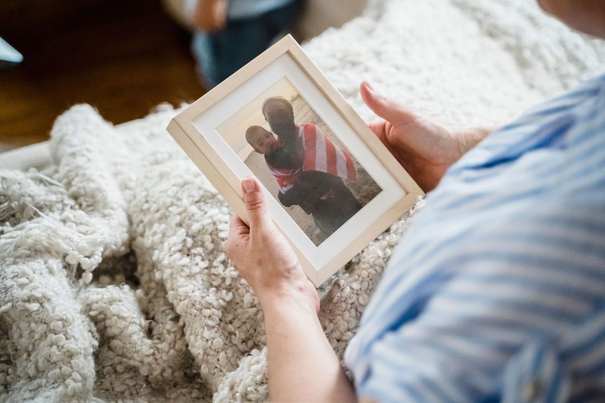 A person holding a family photograph while sitting down