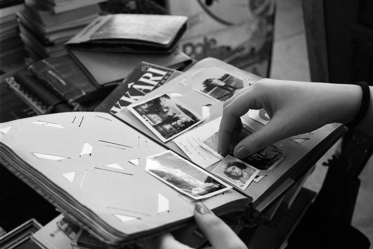 A person turning the pages of an old photo album