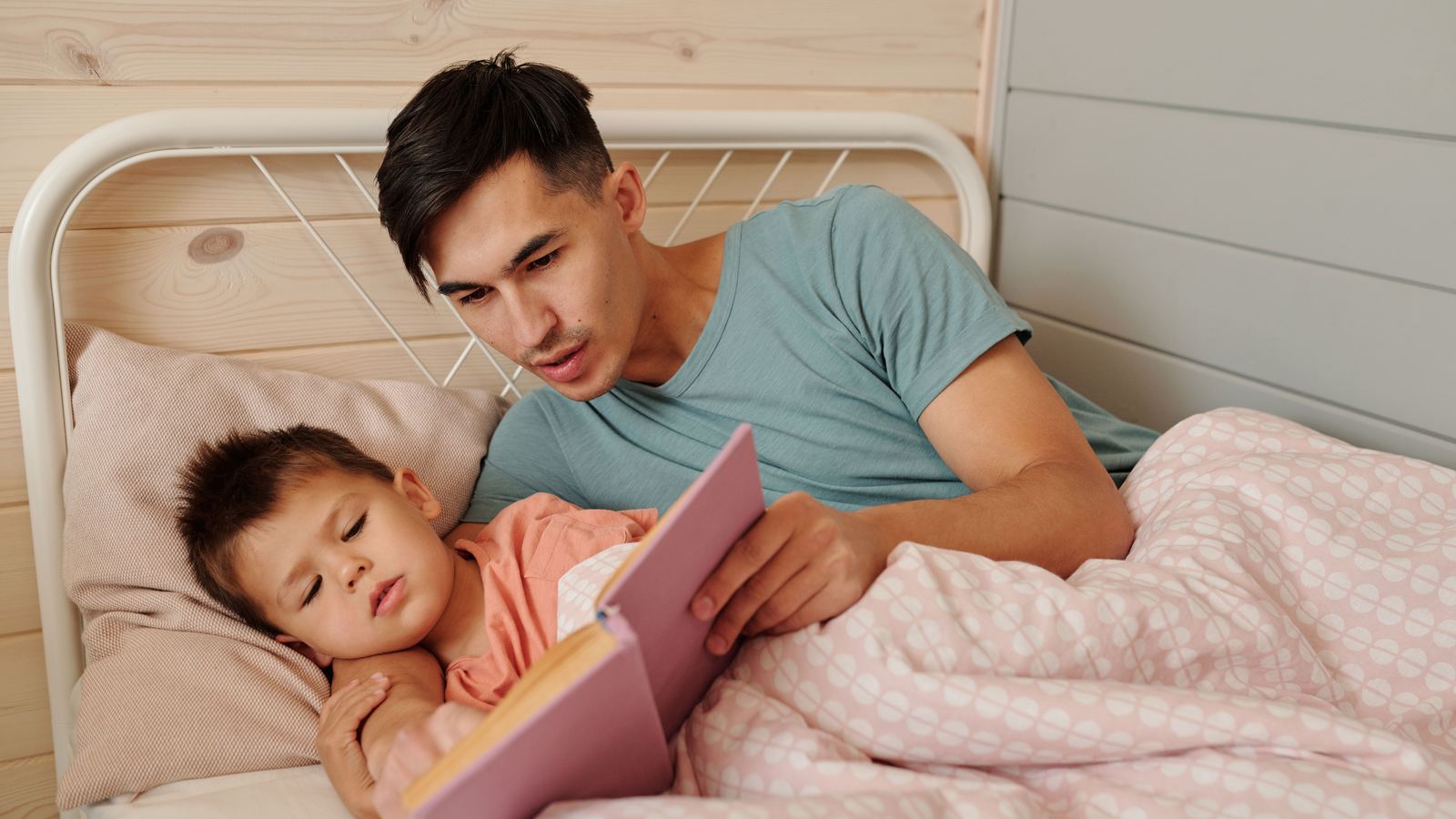 A parent reading a bedtime story to a child at bedtime