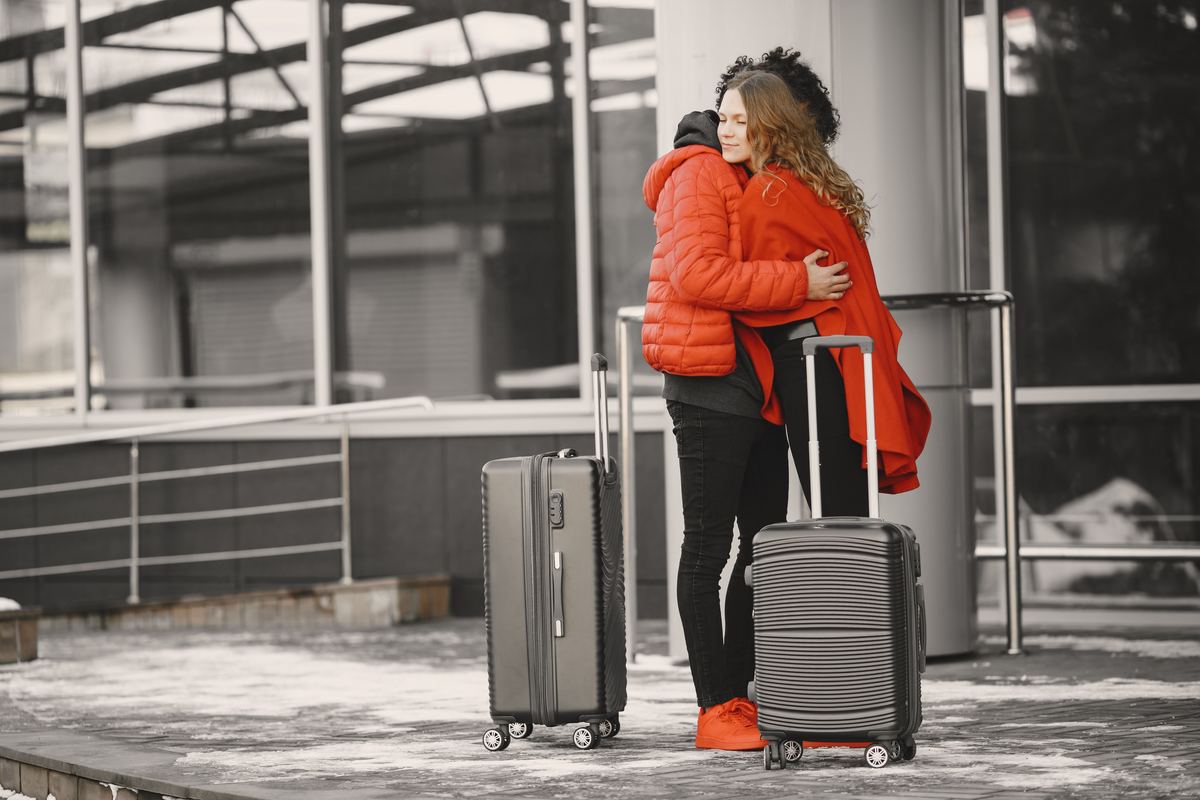 Two people embracing beside luggage before a departure